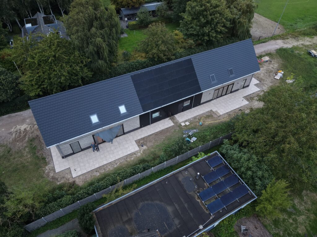 Dak met zonnepanelen en dakramen van dichtbij, vanuit de lucht
