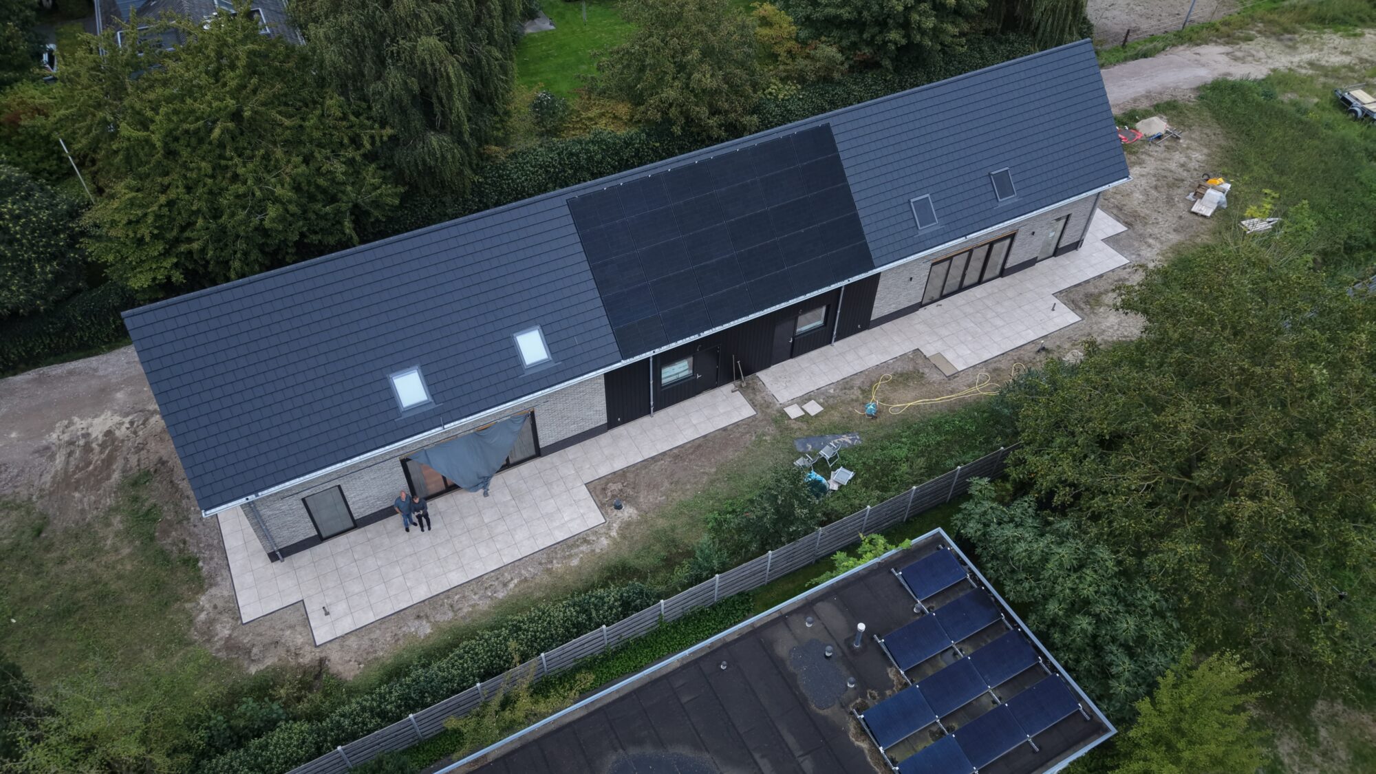 Dak met zonnepanelen en dakramen van dichtbij, vanuit de lucht