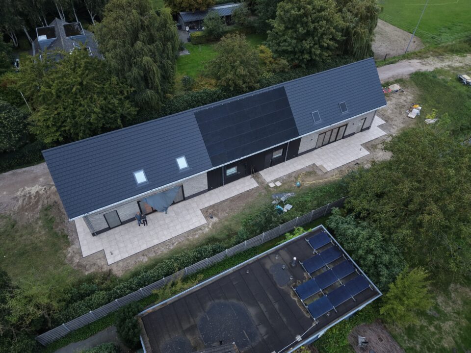 Dak met zonnepanelen en dakramen van dichtbij, vanuit de lucht