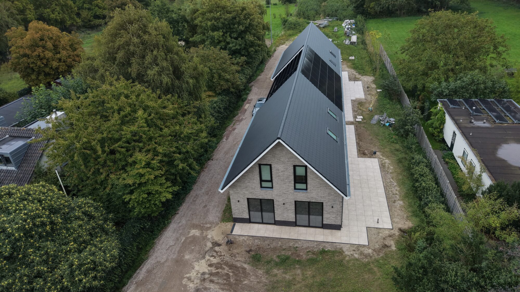 Luchtfoto van een nieuwbouwwoning tussen de bomen