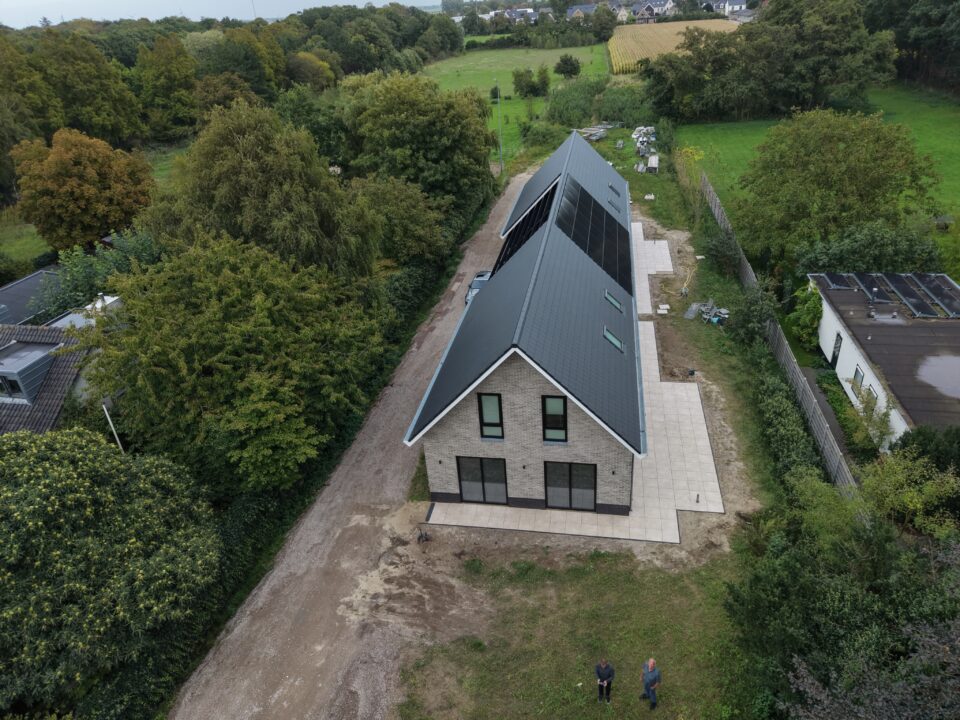 Luchtfoto van een nieuwbouwwoning tussen de bomen